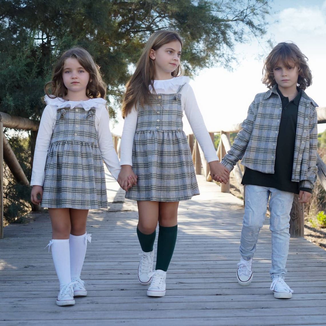 moda infantil tres niños con ropa de cuadros